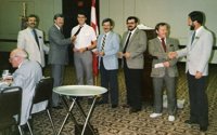 1986 Member Induction: Past Pres. Ted Scharf & Pres. John Collins with new members: Rick Luszczek, Dennis Watson, Jon Janelle and John Watson. At work -- Sec. Tres. Len Woodcock